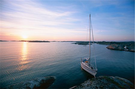 sailboat  ocean - A sailing-boat on calm water. Stock Photo - Premium Royalty-Free, Code: 6102-03748076