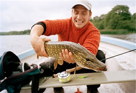 simsearch:6102-08001381,k - A man in a boat holding a pike. Stock Photo - Premium Royalty-Free, Code: 6102-03748465