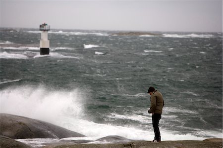 A man standing by a stormy sea. Stock Photo - Premium Royalty-Free, Code: 6102-03750804