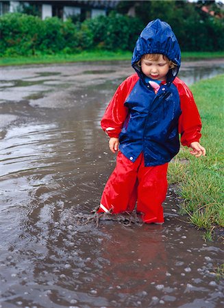 puddle in the rain - A child playing in the rain, Sweden. Stock Photo - Premium Royalty-Free, Code: 6102-03866355