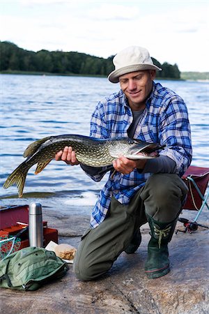 simsearch:6102-08001381,k - A man holding a pike, Sweden. Stock Photo - Premium Royalty-Free, Code: 6102-03867441