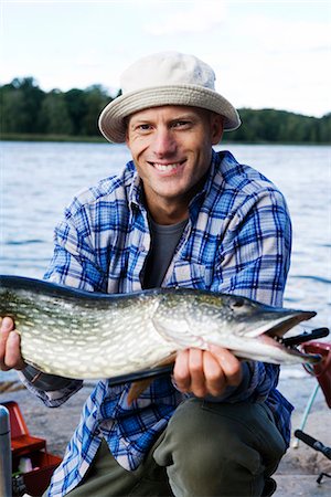 simsearch:6102-08001381,k - A man holding a pike, Sweden. Stock Photo - Premium Royalty-Free, Code: 6102-03867417