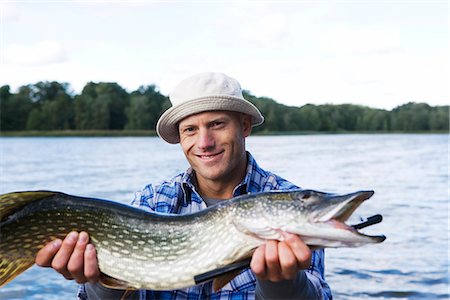 simsearch:6102-08001381,k - A man holding a pike, Sweden. Stock Photo - Premium Royalty-Free, Code: 6102-03867418