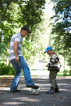 Father and son playing football in a park a sunny day, Sweden. Stock Photo - Premium Royalty-Free, Code: 6102-03867795