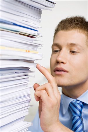 A man with a pile of paper in an office. Stock Photo - Premium Royalty-Free, Code: 6102-03827257
