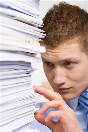 A man with a pile of paper in an office. Stock Photo - Premium Royalty-Free, Code: 6102-03827256