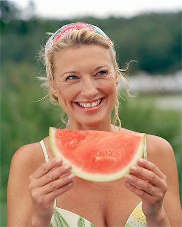 single 40 year old woman laughing - A woman eating a watermelon, Sweden. Stock Photo - Premium Royalty-Free, Code: 6102-03827859