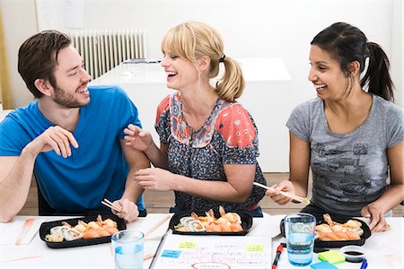 Colleagues in an office having sushi for lunch, Sweden. Stock Photo - Premium Royalty-Free, Code: 6102-03827830