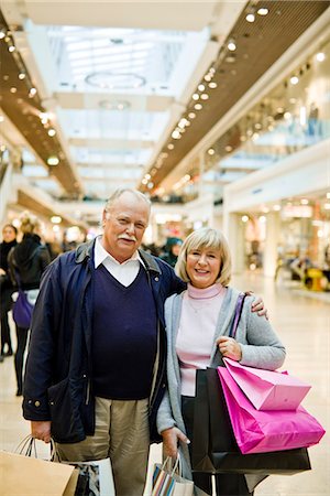 simsearch:6102-06025962,k - Portrait of a senior couple carrying shopping bags, Stockholm, Sweden. Stock Photo - Premium Royalty-Free, Code: 6102-03829136