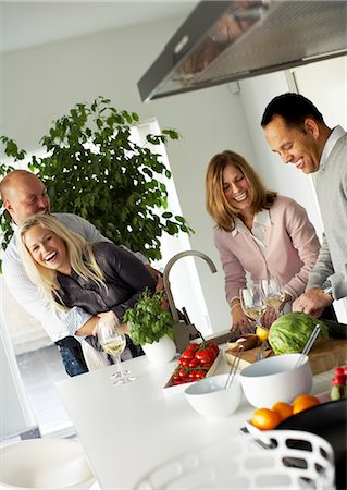 friends cooking inside - Two couples making dinner together, Sweden. Stock Photo - Premium Royalty-Free, Code: 6102-03904057