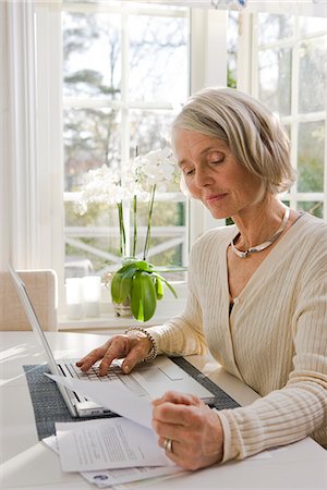 postal - Senior woman using a laptop at home, Sweden. Stock Photo - Premium Royalty-Free, Code: 6102-03904697