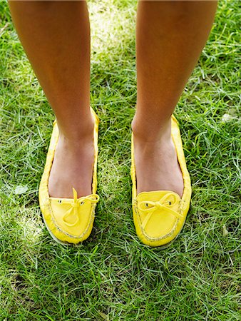 Woman standing on grass with yellow footwear, elevated view Stock Photo - Premium Royalty-Free, Code: 6102-03905762