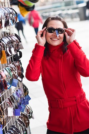 simsearch:6102-06025962,k - Portrait of young woman trying on sunglasses Stock Photo - Premium Royalty-Free, Code: 6102-04929547