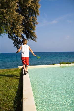 personal - Boy walking on edge of pool Stock Photo - Premium Royalty-Free, Code: 6102-04929567