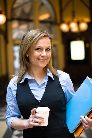 simsearch:6102-07455789,k - Portrait of mid-adult businesswoman holding file and takaway coffee Stock Photo - Premium Royalty-Free, Code: 6102-04929586