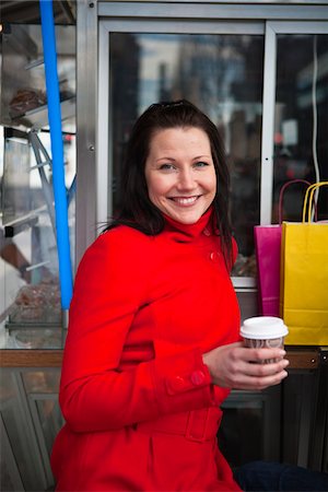 simsearch:6102-06025962,k - Portrait of young woman holding takeaway coffee, with shopping bags in background Stock Photo - Premium Royalty-Free, Code: 6102-04929536