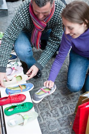 simsearch:6102-06025962,k - Couple observing shoes at outdoor market stall Stock Photo - Premium Royalty-Free, Code: 6102-04929607