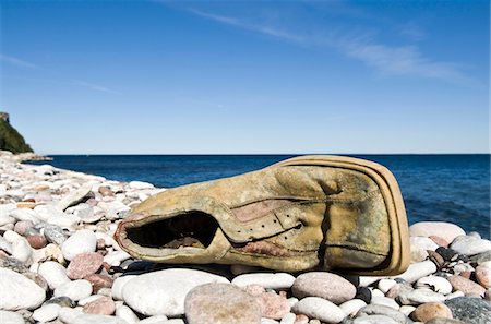 pebbles on shore - Old damaged shoe on stone beach Stock Photo - Premium Royalty-Free, Code: 6102-04929788