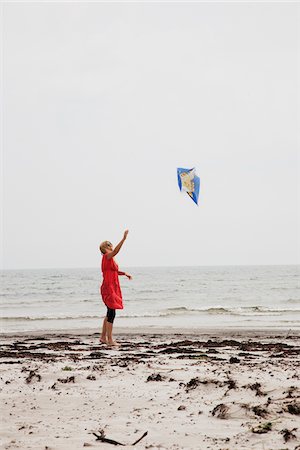 flying happy woman images - Woman flying kite at beach Stock Photo - Premium Royalty-Free, Code: 6102-04929734