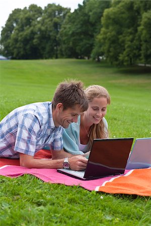Mid adult couple lying on blanket with laptops Stock Photo - Premium Royalty-Free, Code: 6102-04929895