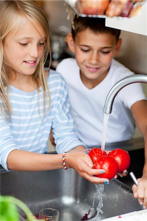 friends cooking inside - A boy and a girl preparing tomatos Stock Photo - Premium Royalty-Free, Code: 6102-05655491