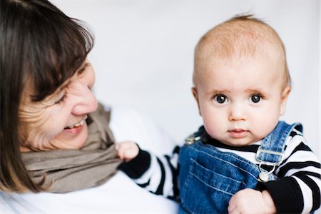 Grandson and grandmother smiling against white background, close-up Stock Photo - Premium Royalty-Free, Code: 6102-05603687