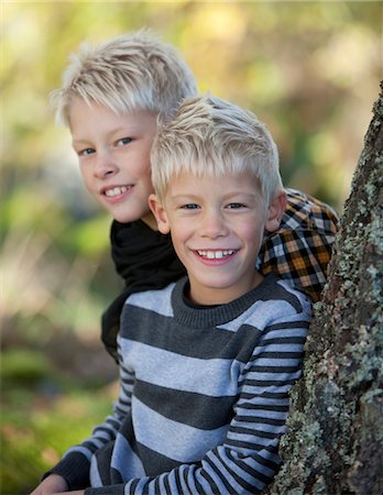 sweden blond boy - Portrait of two blonde boys leaning against tree trunk Stock Photo - Premium Royalty-Free, Code: 6102-05802531