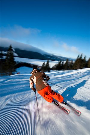 simsearch:6102-07158155,k - Skier going down slope, rear view Stock Photo - Premium Royalty-Free, Code: 6102-05955848