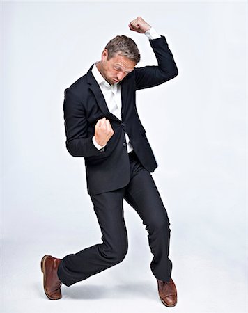 Businessman dancing and punching air Stock Photo - Premium Royalty-Free, Code: 6102-06025837