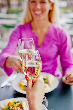 Two women toasting wine at outdoor cafe Stock Photo - Premium Royalty-Free, Code: 6102-06025942