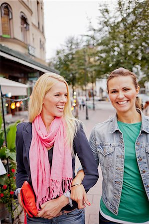 Two women walking arm in arm on pavement Stock Photo - Premium Royalty-Free, Code: 6102-06025971