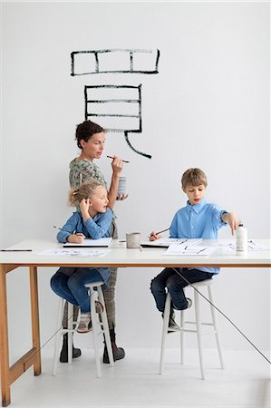 Boy, girl and female teacher caligraphing chinese signs Stock Photo - Premium Royalty-Free, Code: 6102-06336654