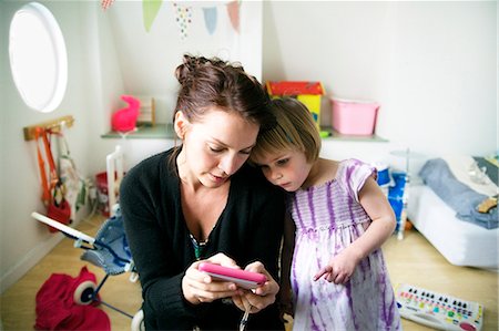 Mother with daughter looking at cell phone Stock Photo - Premium Royalty-Free, Code: 6102-06336602