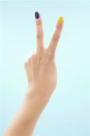 Womans hand making victory sign Stock Photo - Premium Royalty-Free, Code: 6102-06471100