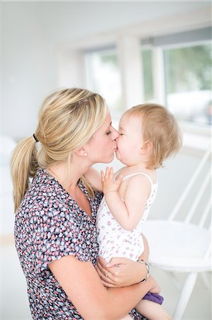 daughter kissing mother - Mother kissing her daughter Photographie de stock - Premium Libres de Droits, Code: 6102-06777270