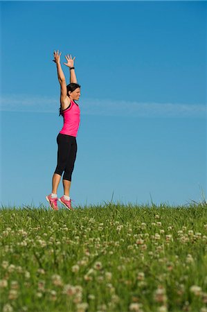 Woman stretching in meadow Stock Photo - Premium Royalty-Free, Code: 6102-06777479