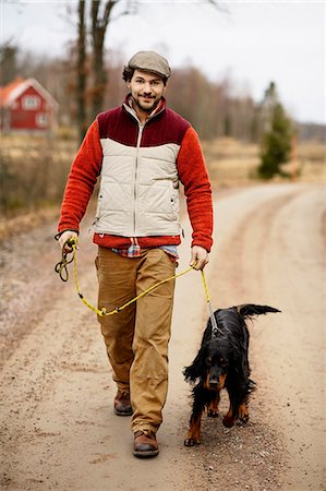 road together - Smiling man walking dog Stock Photo - Premium Royalty-Free, Code: 6102-06777630