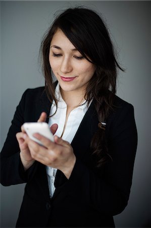 simsearch:6102-06965505,k - Young businesswoman using smartphone Stock Photo - Premium Royalty-Free, Code: 6102-06965449