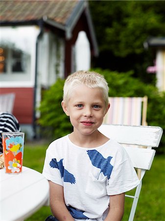 simsearch:6102-06965474,k - Portrait of boy sitting at outdoor table Stock Photo - Premium Royalty-Free, Code: 6102-06965474