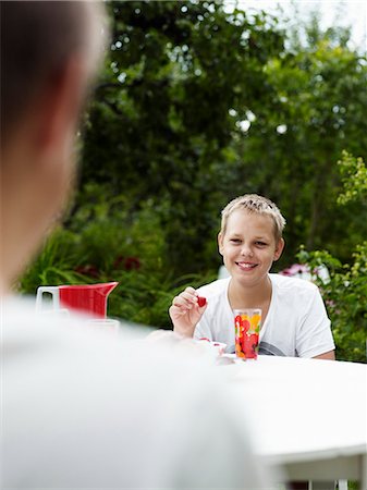 simsearch:6102-06965505,k - Teenage boy talking at outdoor table Stock Photo - Premium Royalty-Free, Code: 6102-06965475