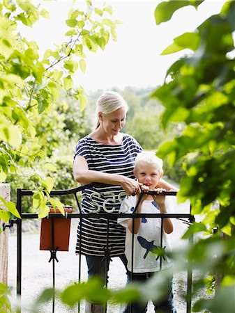 simsearch:6102-06965505,k - Mother and son standing by garden gate Stock Photo - Premium Royalty-Free, Code: 6102-06965497