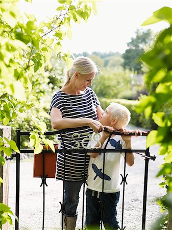 simsearch:6102-06965505,k - Mother and son standing by garden gate Stock Photo - Premium Royalty-Free, Code: 6102-06965496