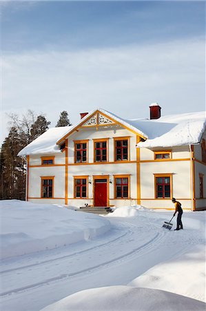 Woman removing snow from driveway Stock Photo - Premium Royalty-Free, Code: 6102-06965685