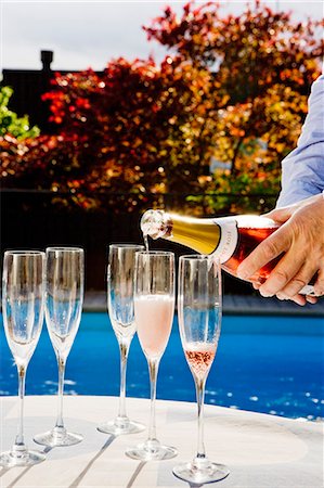pool party - Man pouring champagne, close-up Stock Photo - Premium Royalty-Free, Code: 6102-07158242
