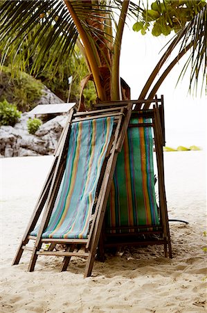 simsearch:400-04587823,k - Sun chairs leaning on palm tree, Thailand Stock Photo - Premium Royalty-Free, Code: 6102-07158334