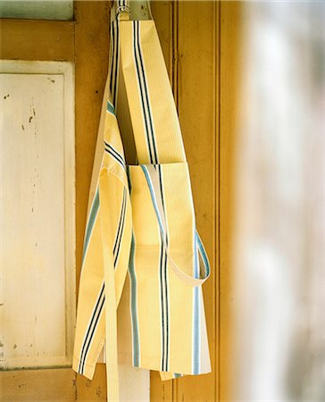 Close-up of yellow apron hanging Stock Photo - Premium Royalty-Free, Code: 6102-07455719