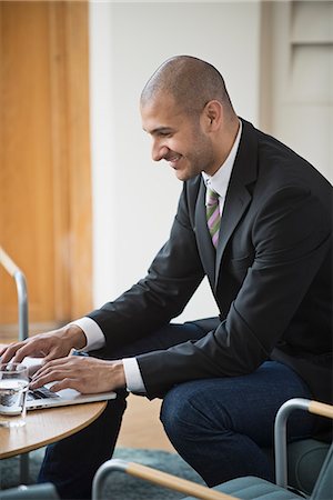 simsearch:6102-07455789,k - Smiling businessman working on laptop, Stockholm, Sweden Stock Photo - Premium Royalty-Free, Code: 6102-07602626