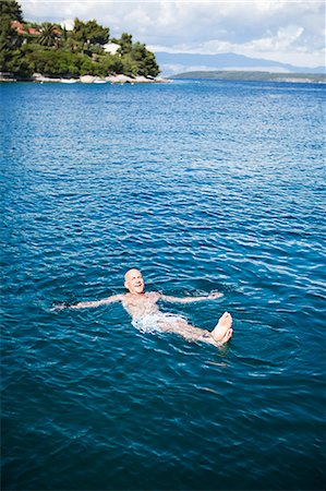 Senior man swimming in sea, Croatia Stock Photo - Premium Royalty-Free, Code: 6102-07602815