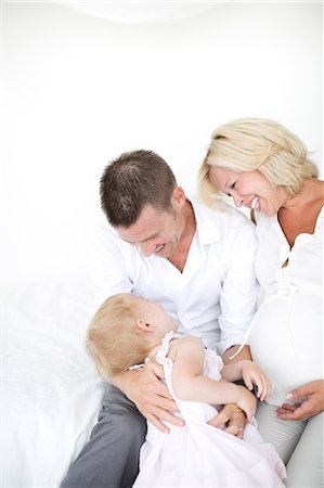 simsearch:6102-08566788,k - Parents playing with daughter on bed, studio shot Stock Photo - Premium Royalty-Free, Code: 6102-07768628
