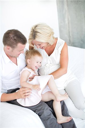 simsearch:6102-08566788,k - Parents playing with daughter on bed, studio shot Stock Photo - Premium Royalty-Free, Code: 6102-07768630